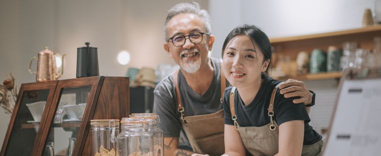 senior-shop-owner-with-young-help